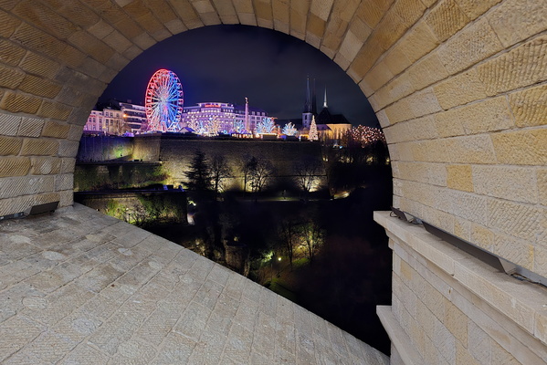 A city’s glow, framed by old stone