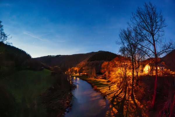 The river runs, and the lights dance on